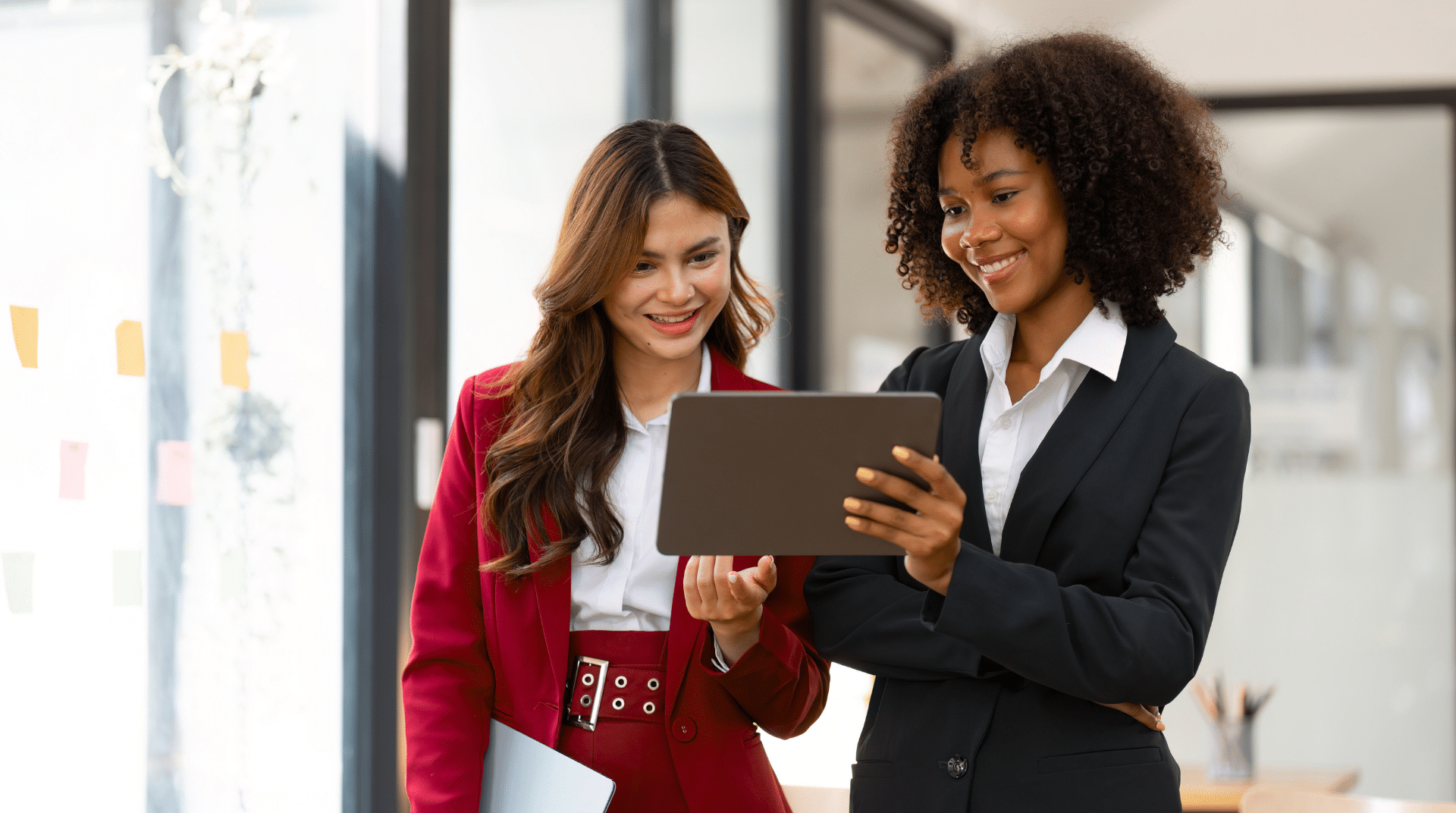 Two business women in office discussing the benefits of financial wellness